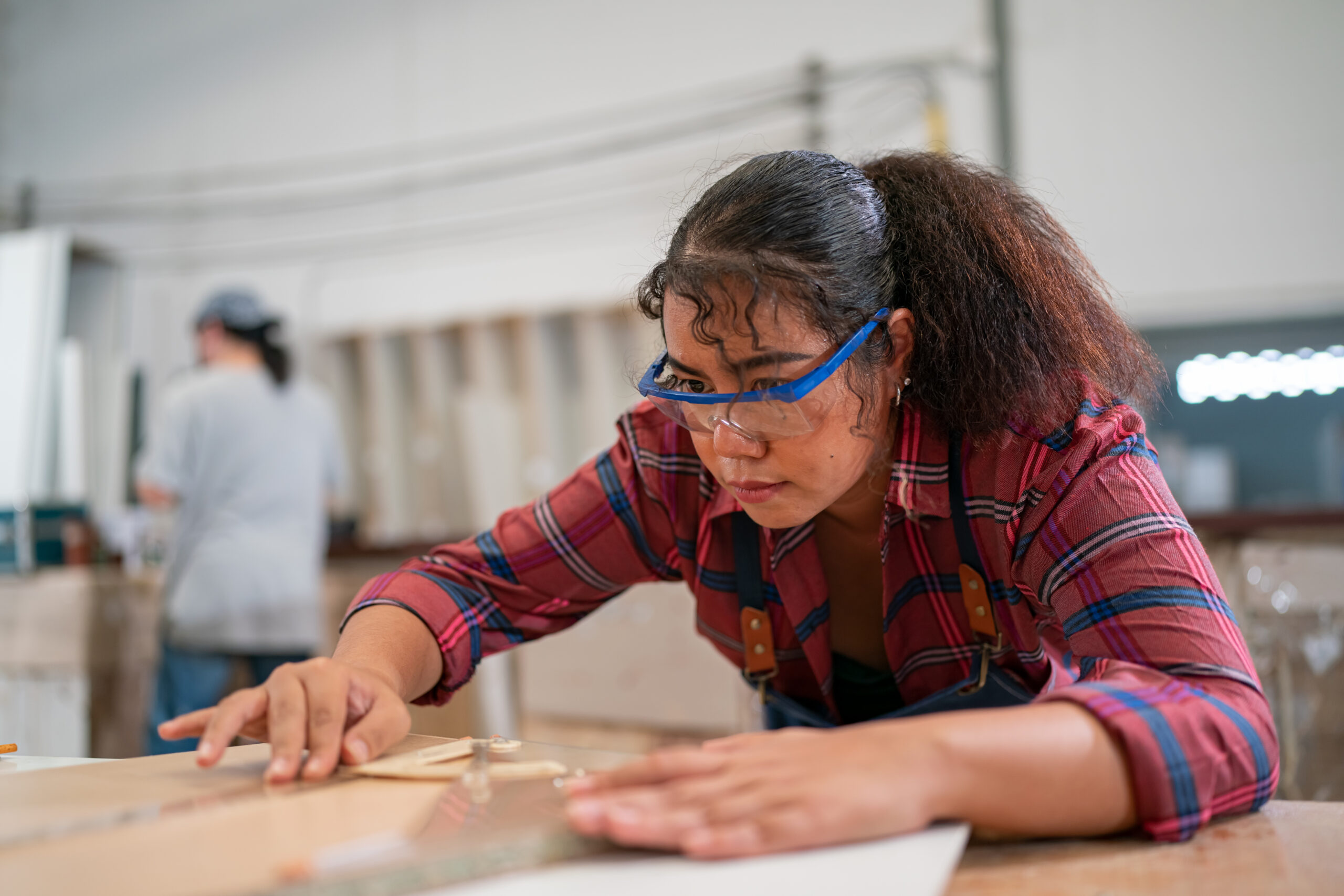 carpenter using sander while working on a piece of wood.